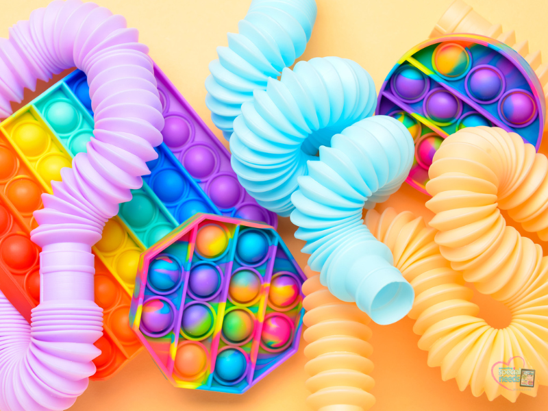 Fidget toys including pop-it toys and colorful flexible tubes.