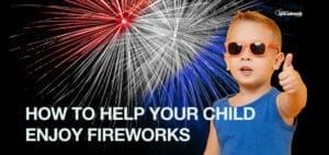 Boy in sunglasses gives a thumbs up with fireworks in the background.