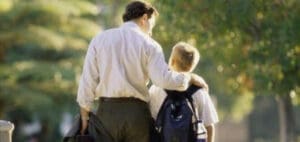 Father with arm around son walking outdoors
