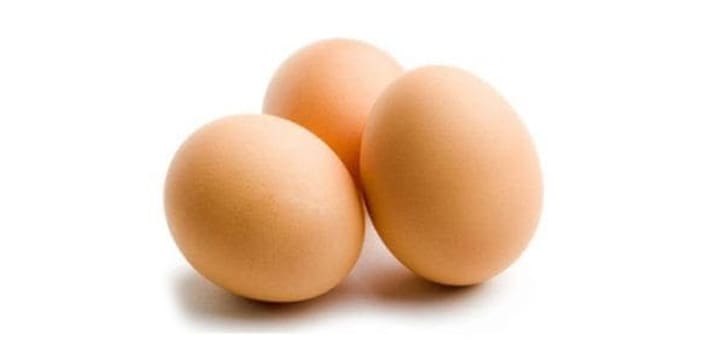 Three brown eggs arranged on a white background