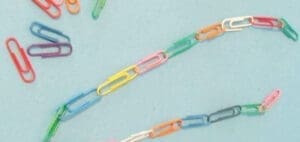 Chains of colorful paper clips on a light blue background.