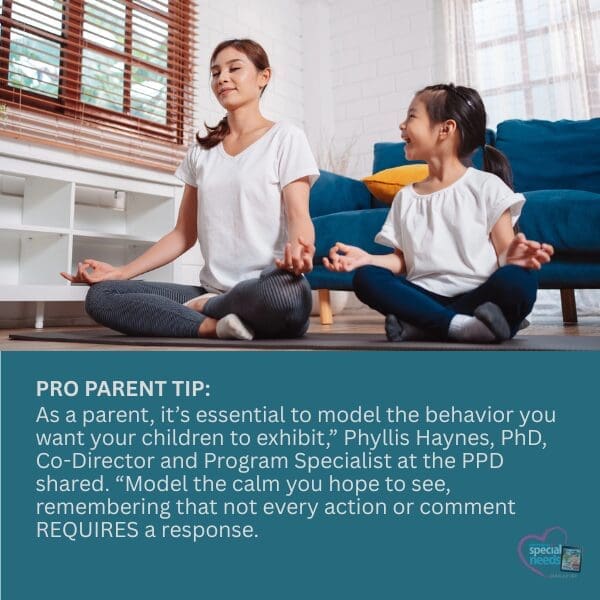 A woman and child meditate on yoga mats in a living room.