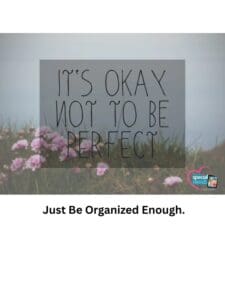 A sign that reads "It's Okay Not To Be Perfect" with pink flowers in the foreground.