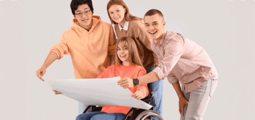 Four students review a blueprint, one in a wheelchair.