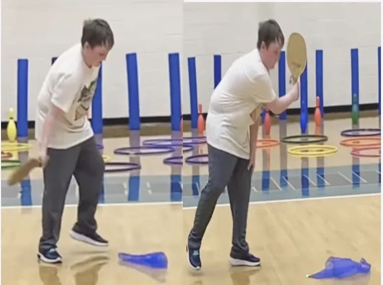 A child practices pickleball skills with a paddle and a blue marker on a gym floor.